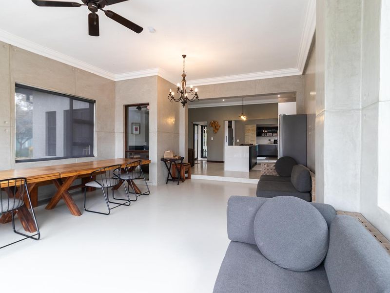 Spacious open-plan living and dining area featuring modern concrete wall panels, coved cornicing, and a seamless transition into the kitchen space.
