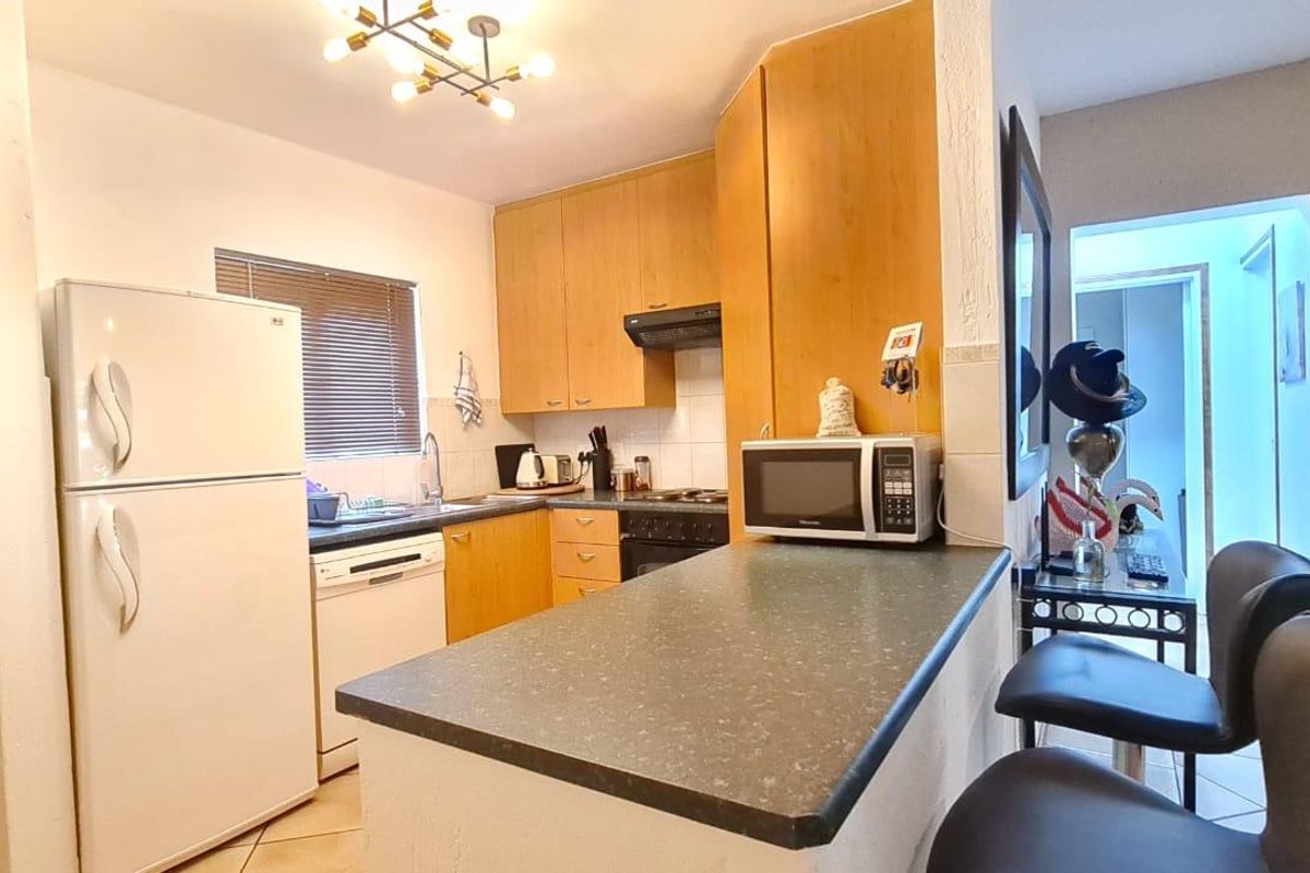 A functional kitchen featuring laminate cabinetry, a breakfast bar, and integrated appliances, offering a practical layout for daily cooking and dining.