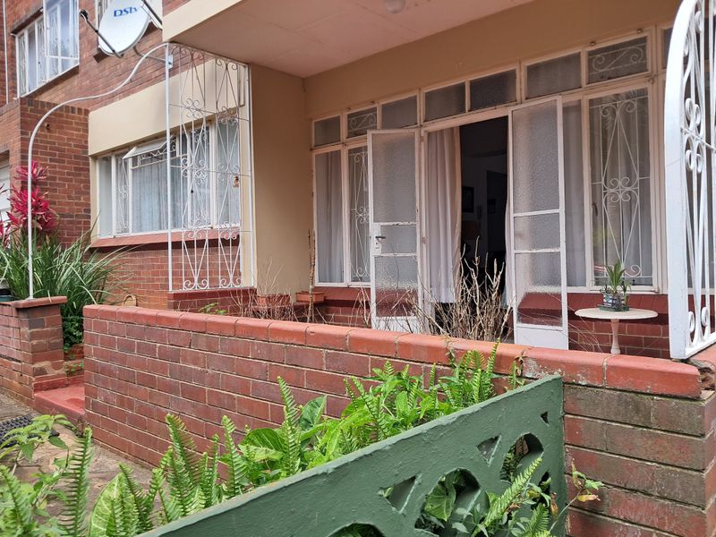 Ground floor patio area featuring brick boundary walls, wrought iron security features, and direct access to the interior through glass panelled doors.