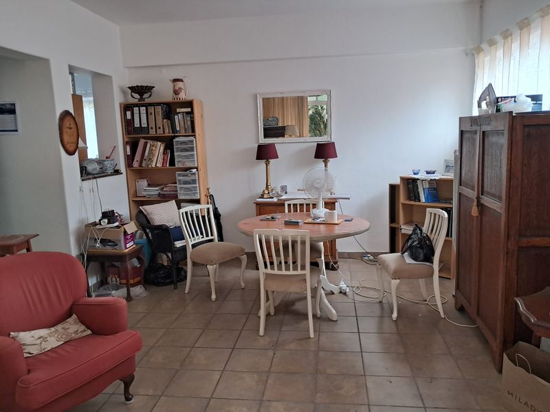 A functional dining area featuring tiled flooring and a convenient pass-through window connecting to the adjacent kitchen space.