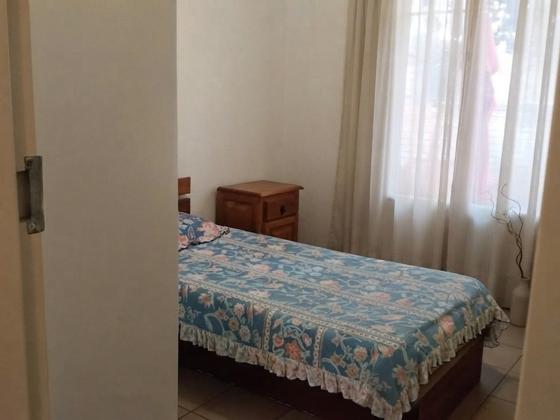 A bedroom featuring tiled flooring and window treatments, viewed from the doorway.