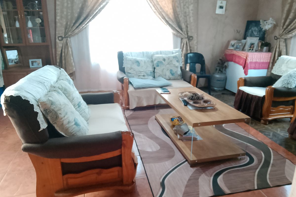 A living room area featuring tiled flooring with visible damage, requiring maintenance or renovation to improve the overall condition of the space.