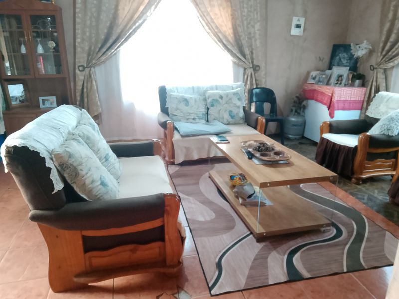 A living room area featuring tiled flooring with visible damage, requiring maintenance or renovation to improve the overall condition of the space.