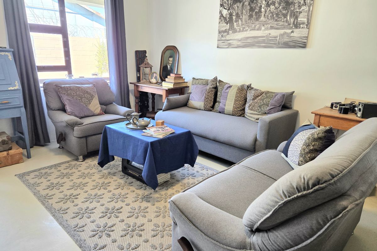 A comfortable living room featuring neutral walls, large window for natural light, and smooth flooring, providing a versatile space for relaxation.