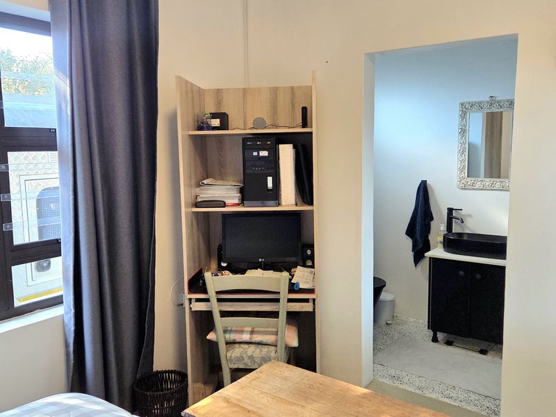 Bedroom featuring an en-suite bathroom with a modern vanity, vessel sink, and black fixtures, providing convenient private facilities.