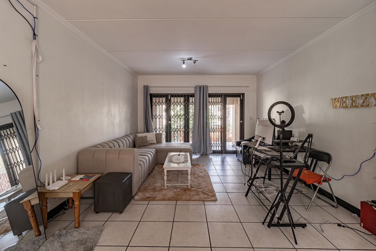 Spacious living room featuring tiled flooring and sliding glass doors leading to an outdoor area, providing natural light and access.