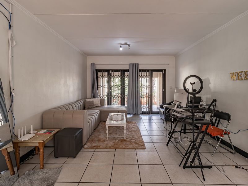 Spacious living room featuring tiled flooring and sliding glass doors leading to an outdoor area, providing natural light and access.