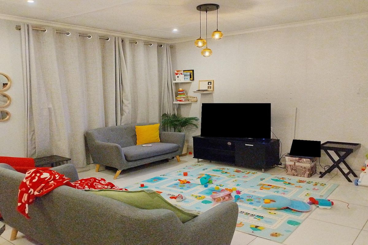 A comfortable living room featuring tiled flooring and recessed lighting, providing a functional space for relaxation and family activities.