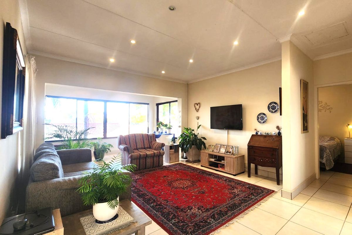 Spacious living room featuring tiled flooring, recessed downlighting, and large windows that provide ample natural light.