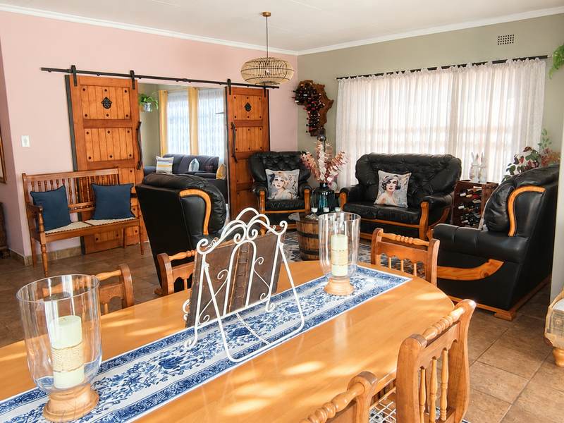 Spacious living area featuring tiled flooring, sliding barn doors, and neutral wall tones, offering a versatile layout for comfortable family living.