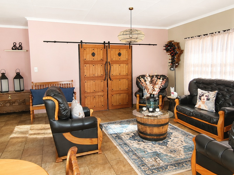 A spacious living room featuring tiled flooring, decorative sliding barn doors, and neutral wall tones, offering a comfortable and well-maintained living space.