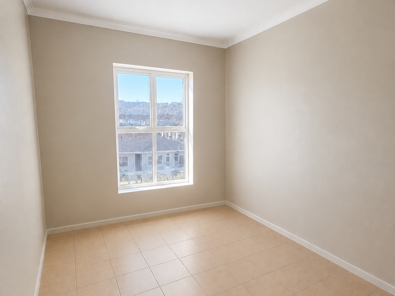 A bright, empty bedroom featuring neutral wall paint, tiled flooring, and a central ceiling light fixture, offering a clean canvas for personalization.