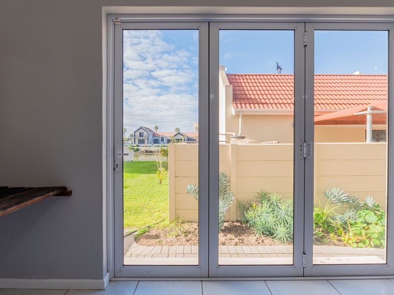 Bright living area featuring modern white bi-fold doors that open onto a private garden and patio space.