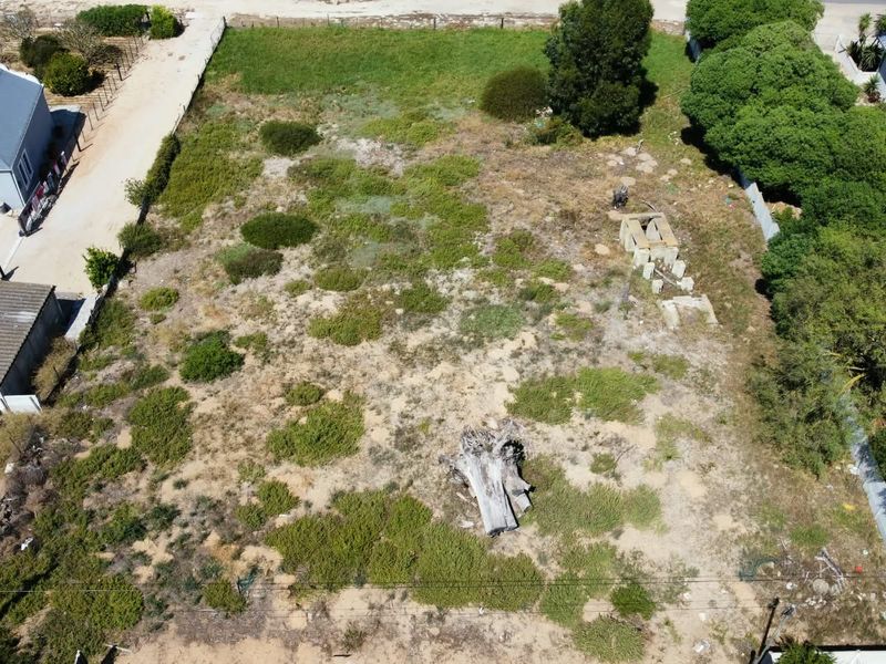 Aerial view of a vacant residential plot featuring natural vegetation and perimeter fencing, offering a blank canvas for future development.