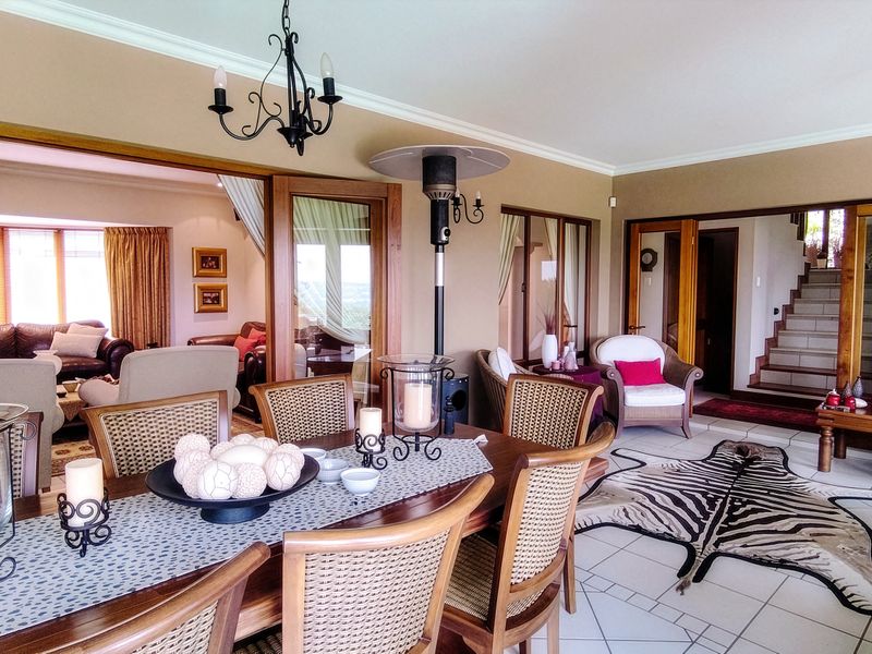 Spacious covered patio area featuring tiled flooring, elegant wrought iron lighting, and seamless access to the interior living spaces through large sliding glass doors.
