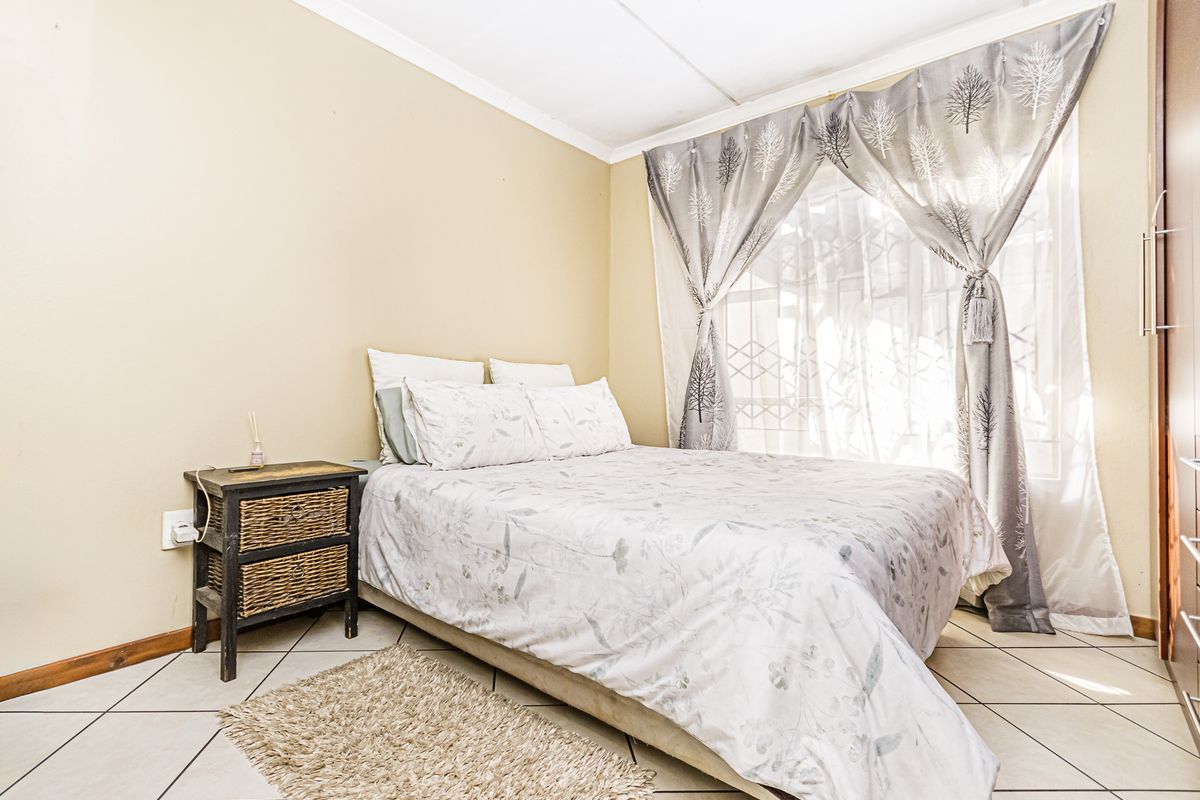 A functional bedroom featuring tiled flooring and a built-in wardrobe, offering a neutral canvas for personalization.