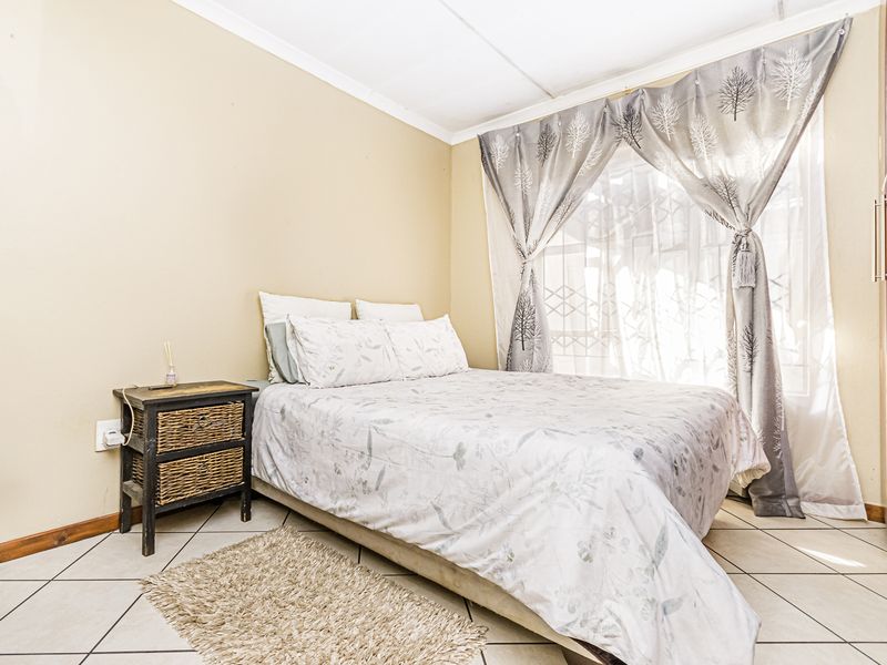 A functional bedroom featuring tiled flooring and a built-in wardrobe, offering a neutral canvas for personalization.