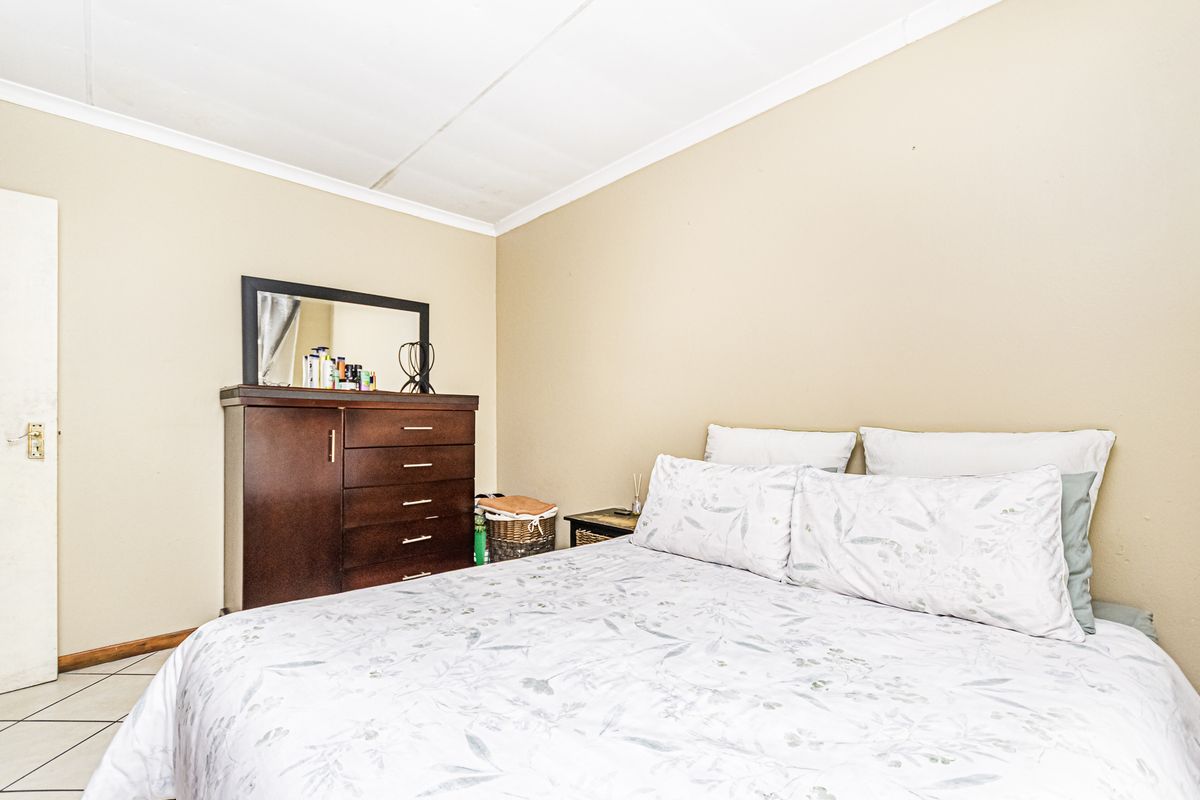 A standard bedroom featuring tiled flooring and a coved ceiling, providing a functional and neutral space.