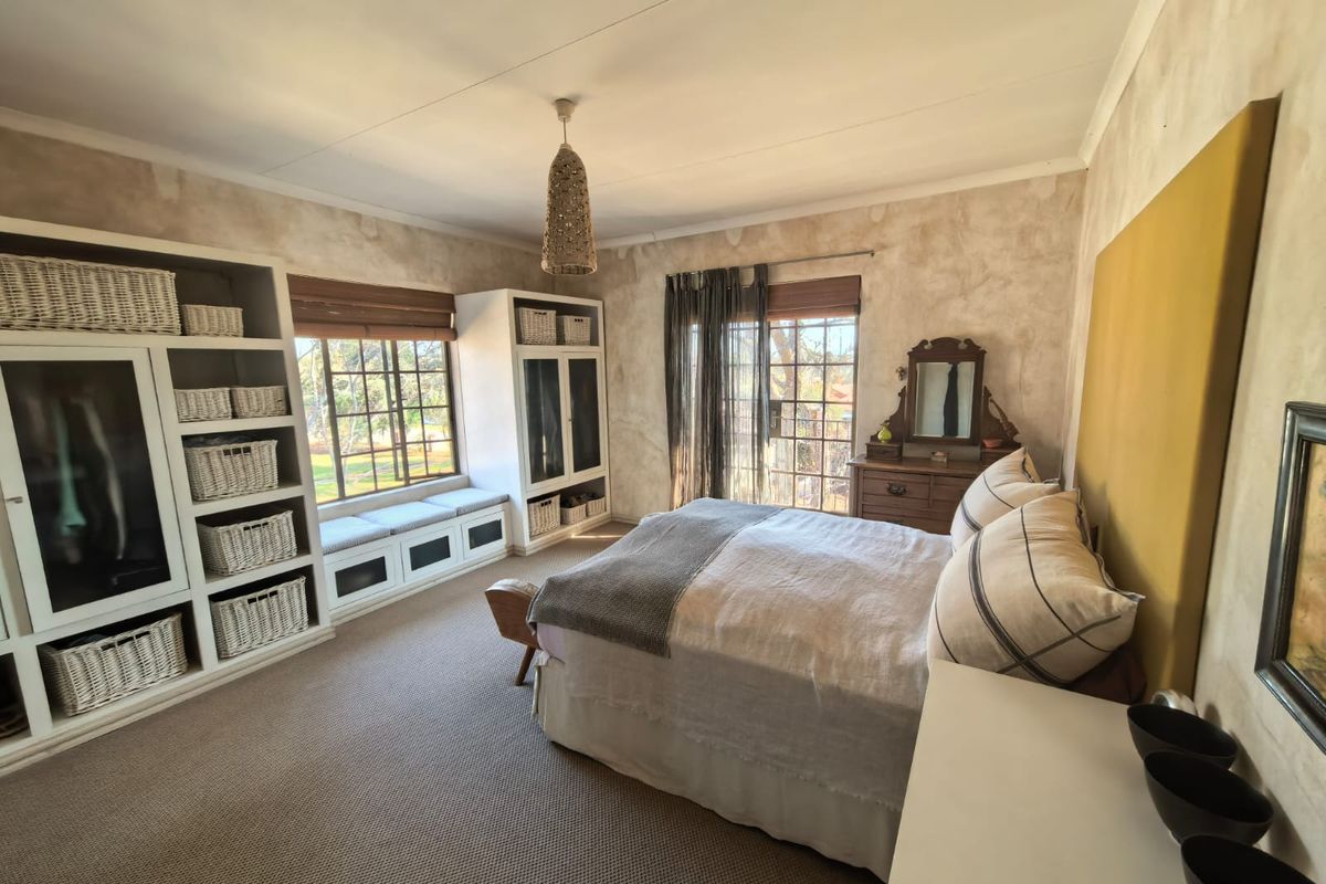 Spacious bedroom featuring built-in storage cabinetry, a window seat, and sliding glass doors providing access to the exterior.