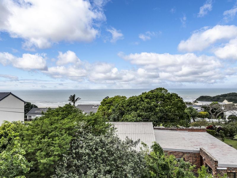 An elevated view overlooking the surrounding residential area with a clear outlook towards the coastline and ocean.