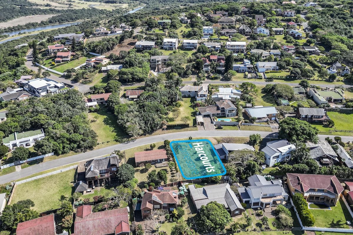 Aerial view of a vacant residential plot situated within an established coastal neighborhood, offering potential for new development.
