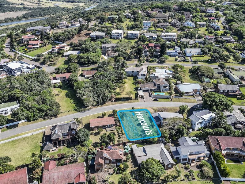 Aerial view of a vacant residential plot situated within an established coastal neighborhood, offering potential for new development.