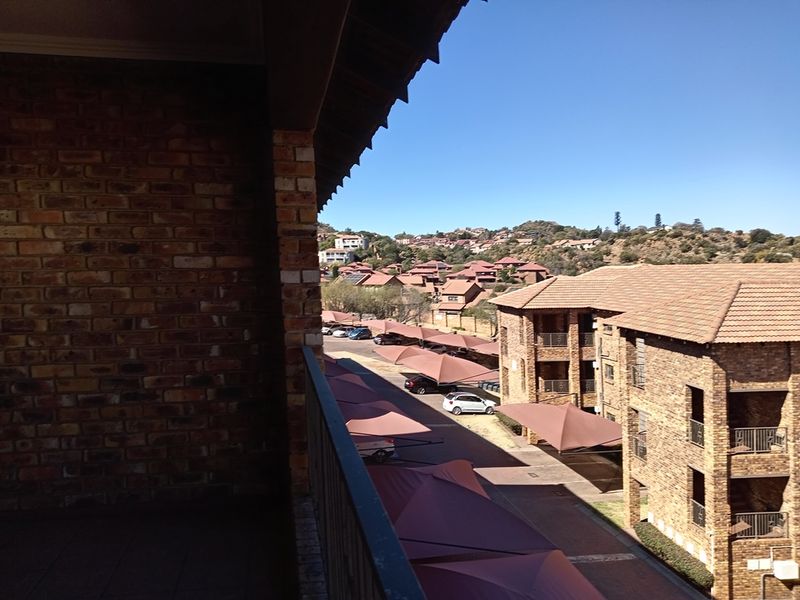A view from a balcony overlooking the townhouse complex parking area and surrounding neighborhood.