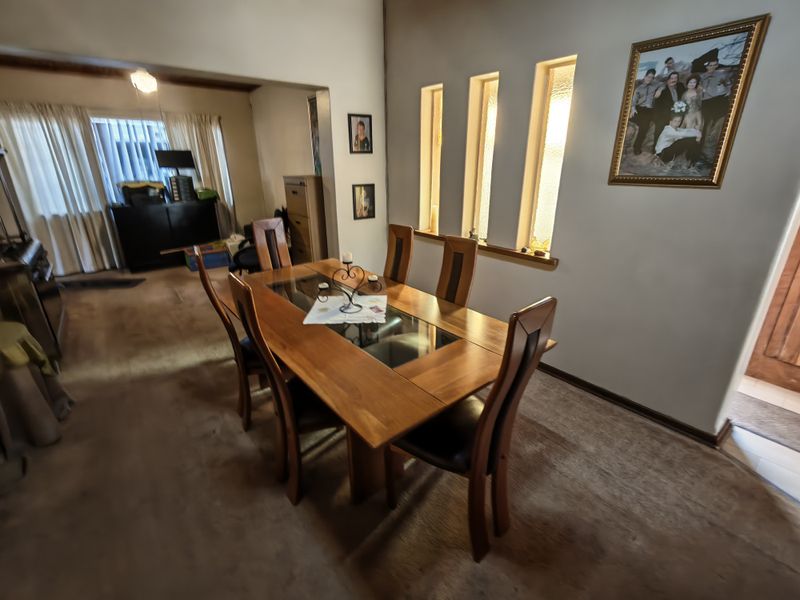 Dining room featuring vertical slit windows and carpeted flooring, providing a functional space for family meals.