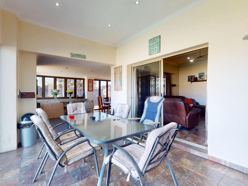 A covered patio area featuring tiled flooring and recessed lighting, providing seamless indoor-outdoor flow through large sliding glass doors.