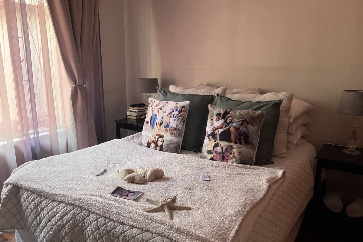 A cozy bedroom featuring a double bed, bedside tables, and natural light from a side window.