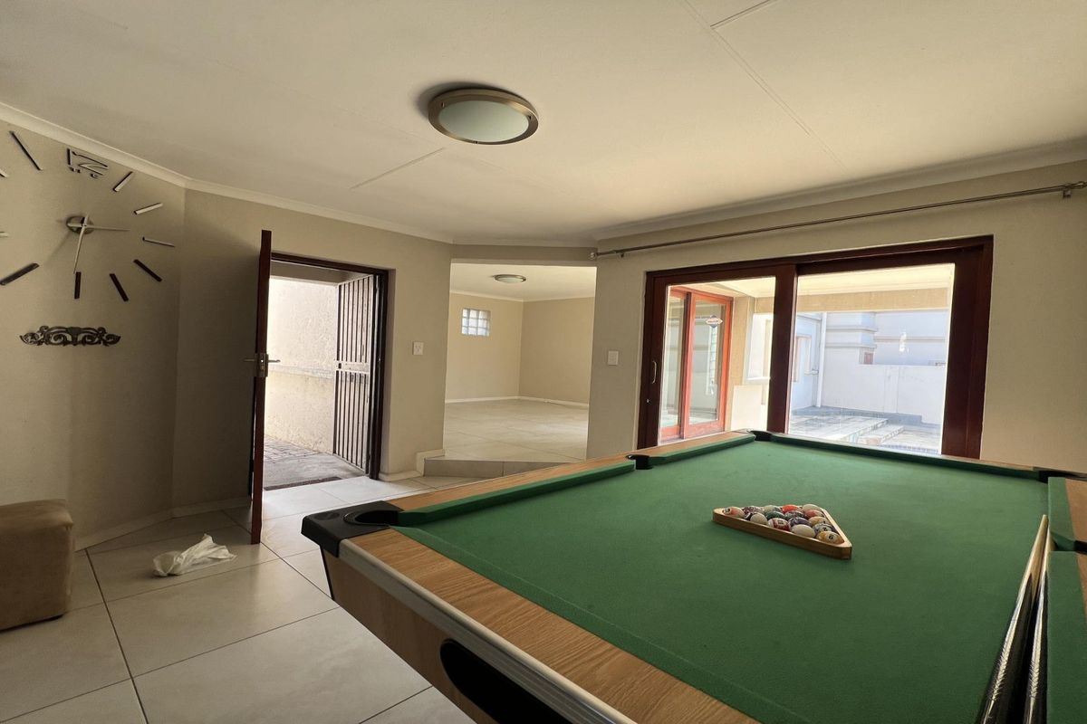 Spacious living area featuring tiled flooring, coved ceilings, and large sliding glass doors providing access to the outdoor patio area.