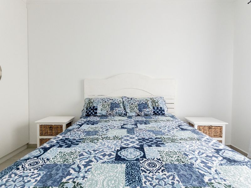 A clean and well-maintained bedroom featuring a built-in wardrobe and neutral finishes.