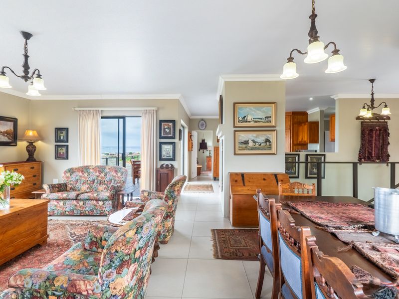 Spacious open-plan living and dining area featuring tiled floors, neutral walls, and direct access to an outdoor patio through sliding glass doors.