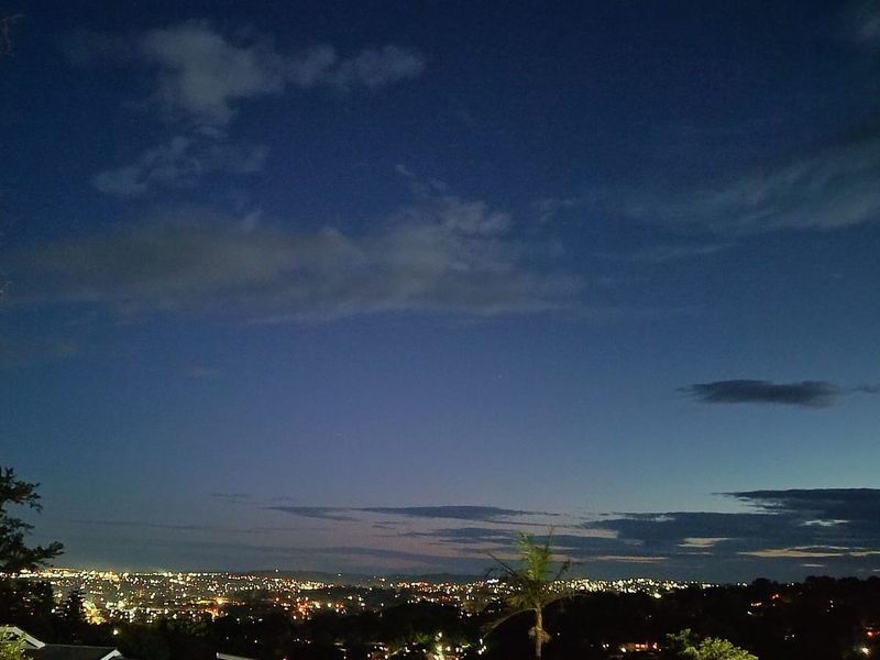 A night-time view overlooking the city lights and horizon.