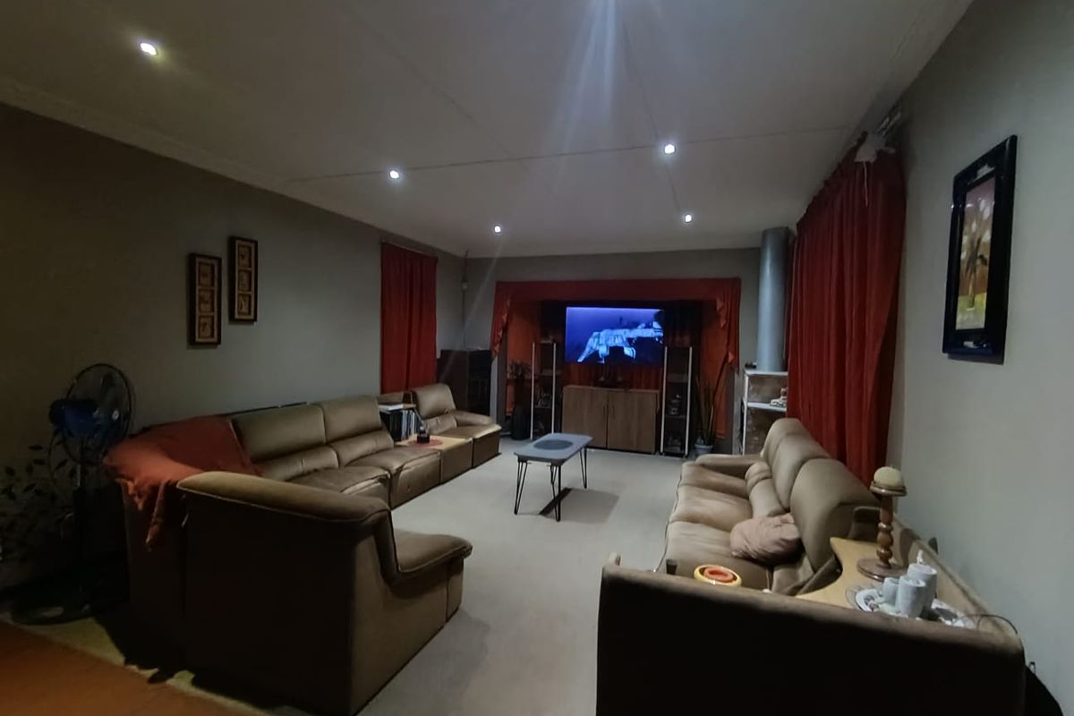 Spacious living room featuring recessed downlighting and a fireplace flue, offering a comfortable and functional layout for family relaxation.