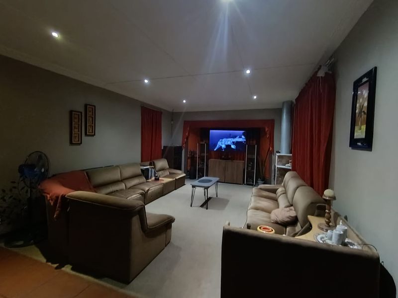 Spacious living room featuring recessed downlighting and a fireplace flue, offering a comfortable and functional layout for family relaxation.