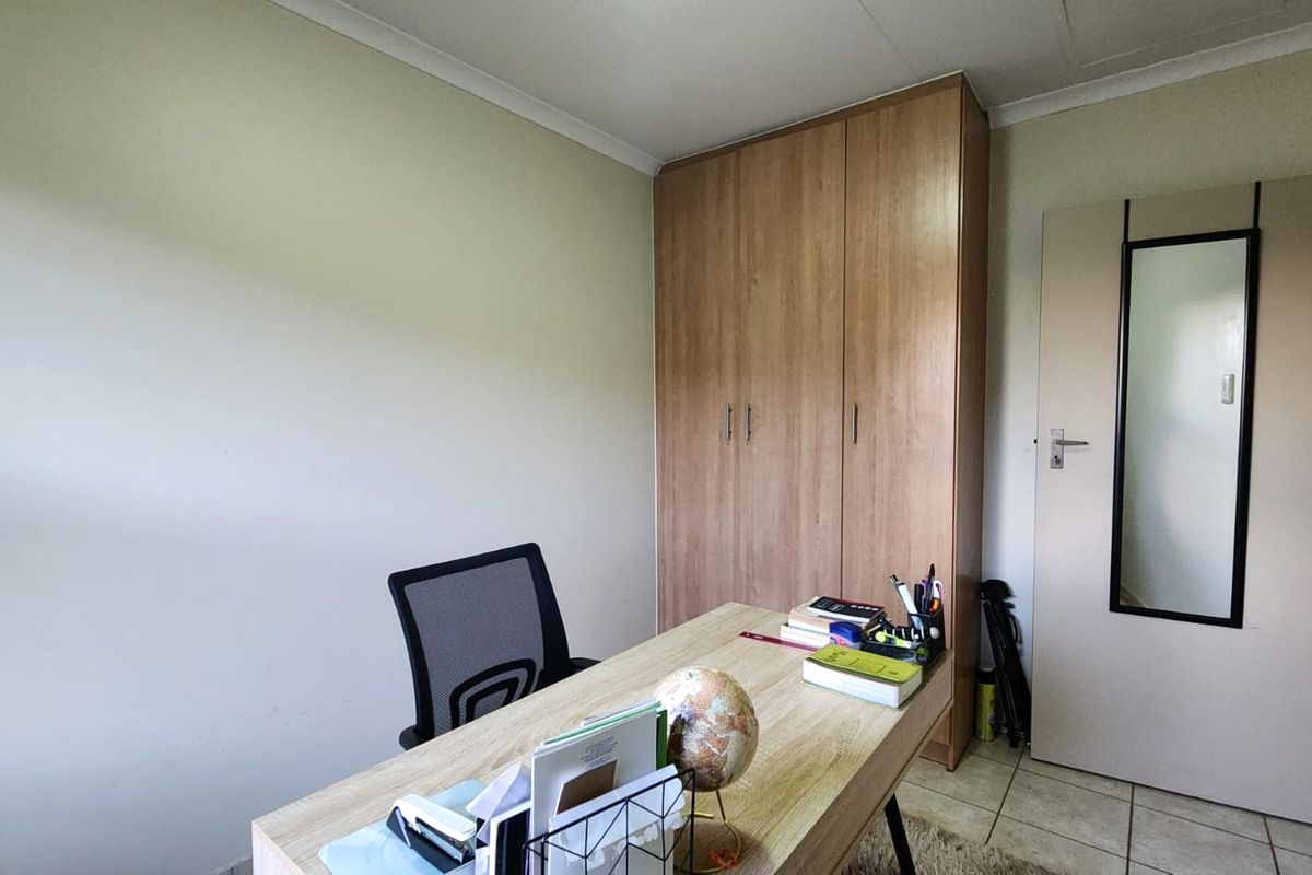 A bedroom featuring tiled flooring, a coved ceiling, and a built-in wooden wardrobe.
