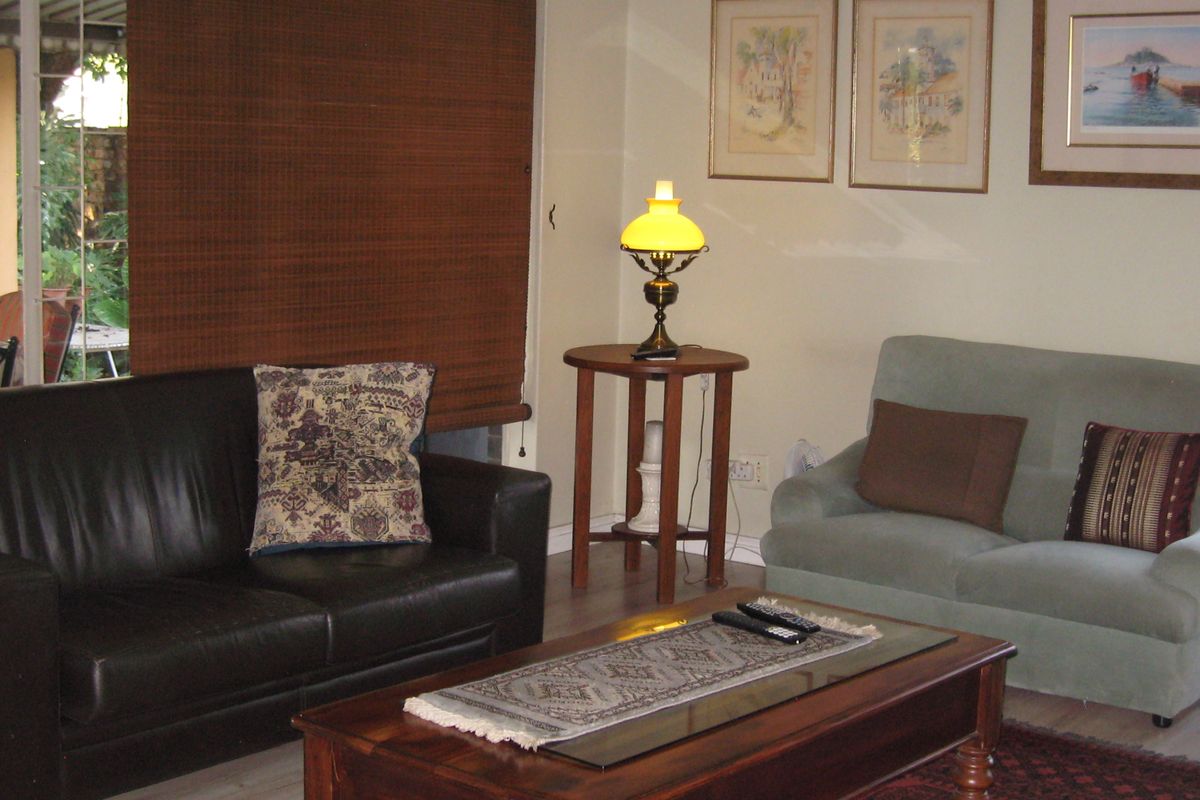 A comfortable living room featuring laminate flooring and a sliding glass door providing access to the outdoor patio area.