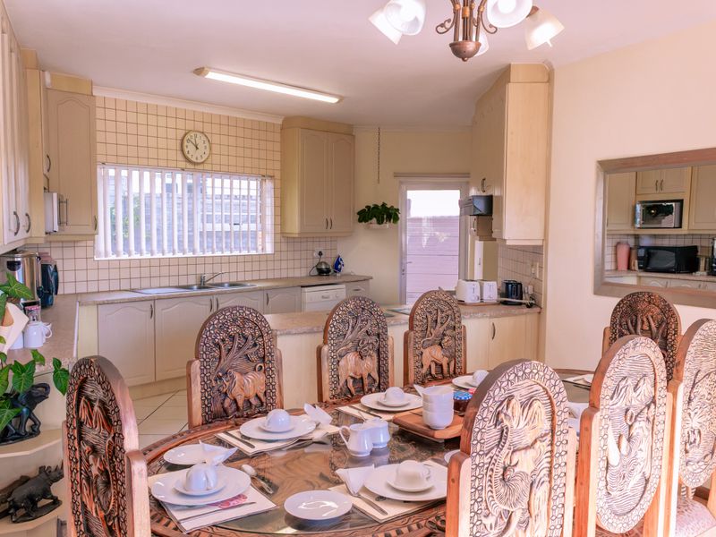 Open plan kitchen and dining area featuring built-in cabinetry, tiled backsplash, and a functional layout suitable for family meals and entertaining.