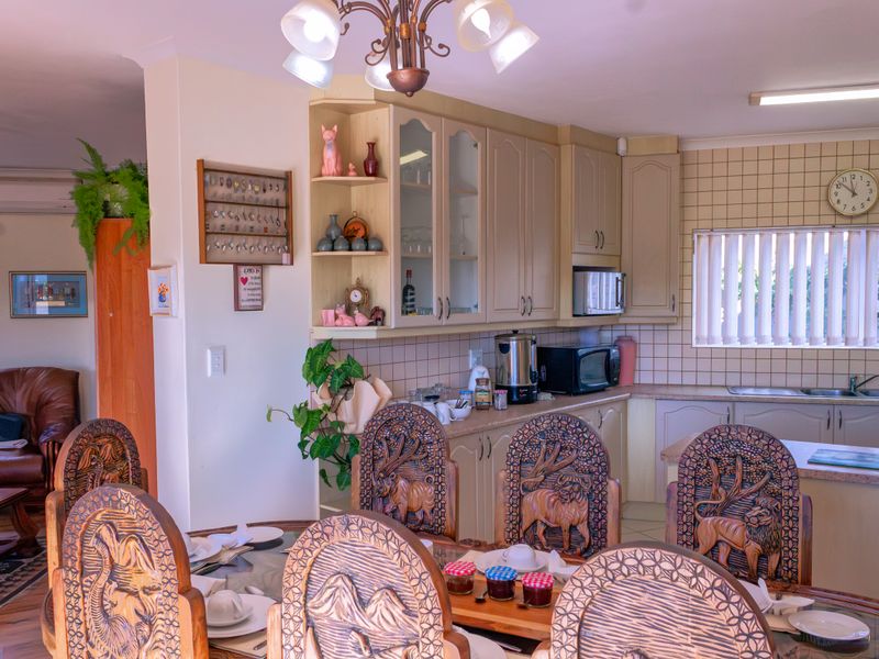 Open plan kitchen and dining area featuring traditional cabinetry, tiled backsplash, and functional layout, suitable for modern updates.