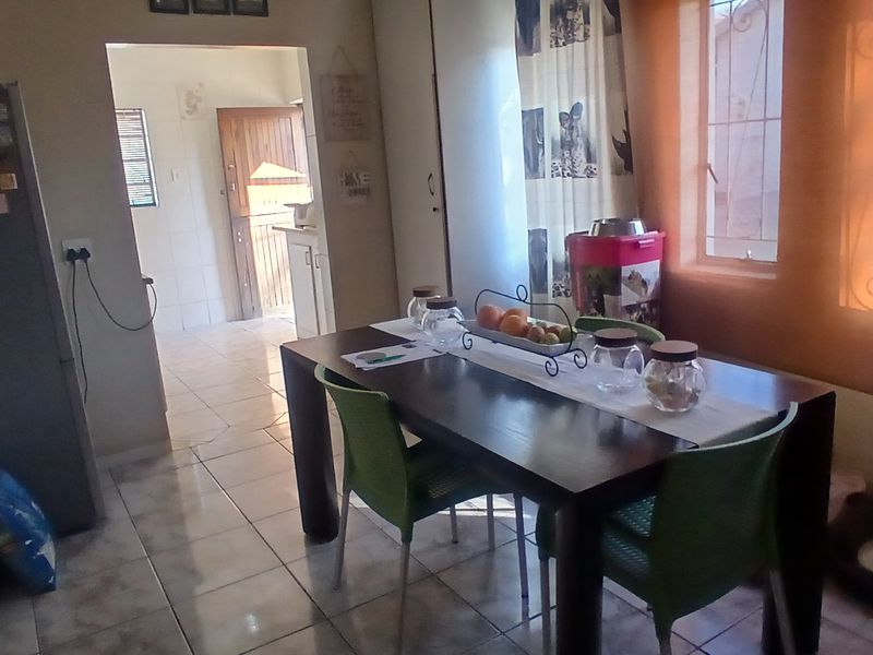 A functional dining area featuring tiled flooring and built-in storage, with an open transition leading into the adjacent kitchen space.