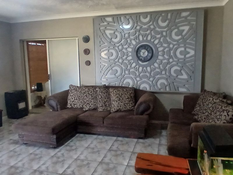 A living room featuring tiled flooring, a sliding door, and a large decorative wall panel.