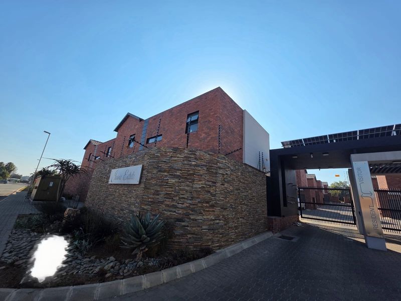 The entrance to the estate features a modern face brick facade, stone cladding, secure gated access, and solar-powered infrastructure.