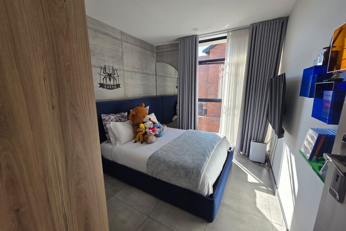 Modern bedroom featuring a concrete accent wall, large format floor tiles, and floor-to-ceiling curtains providing ample natural light.