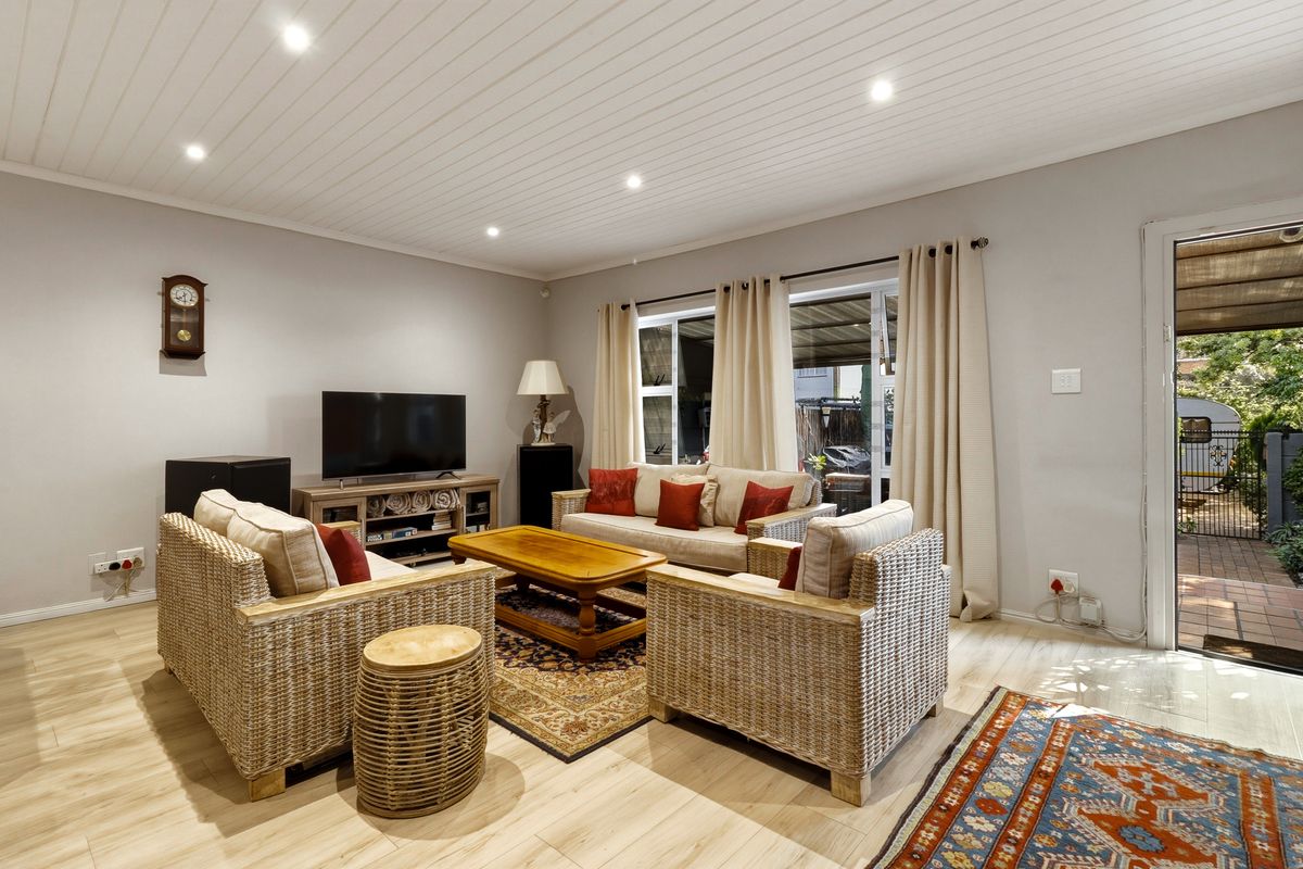 Bright living room featuring light-toned laminate flooring, a tongue and groove ceiling with recessed lighting, and direct access to an outdoor patio area.