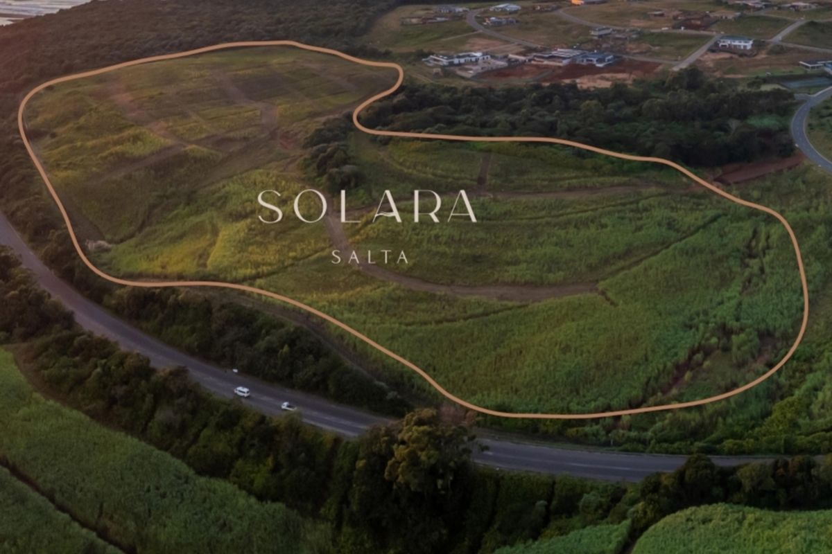An aerial view of a large, undeveloped residential land parcel in a coastal estate setting, highlighting the property boundaries and surrounding landscape.