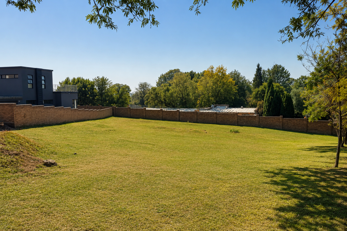 A spacious, well-maintained residential garden featuring a manicured lawn and a secure brick boundary wall.