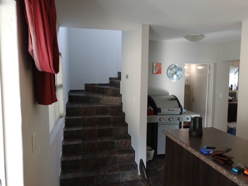 Open plan living area featuring a tiled staircase and a kitchen island with built-in cabinetry.