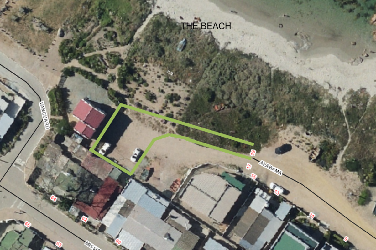 Aerial view of a vacant residential plot situated in a coastal location with direct proximity to the beach.