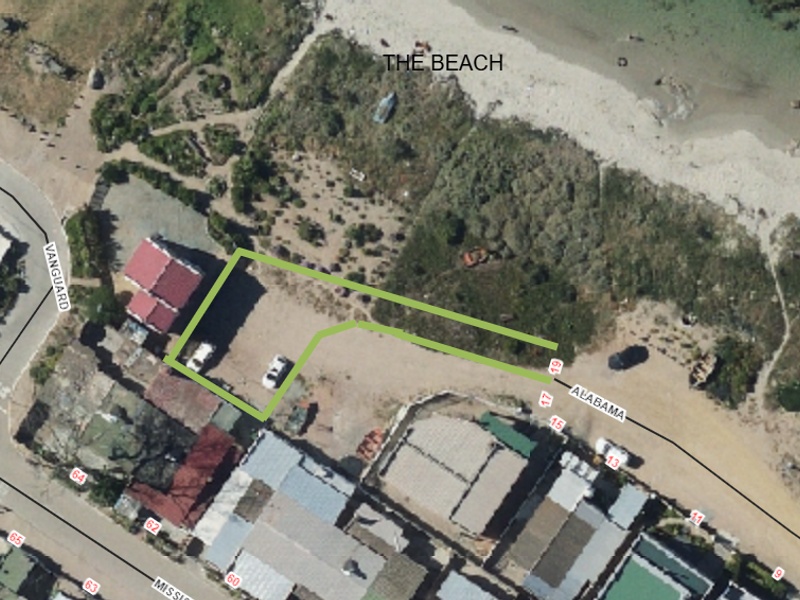 Aerial view of a vacant residential plot situated in a coastal location with direct proximity to the beach.